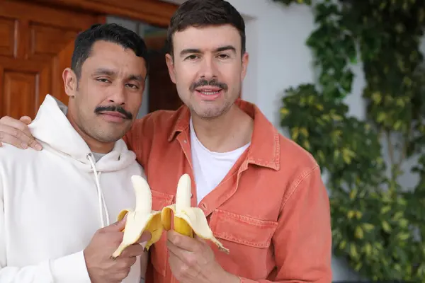 Joven Feliz Gay Pareja Dos Guapo Hombres Con Bananas Fotos de stock libres de derechos