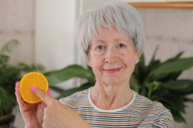 Kıdemli kadın meyvenin içini gösteriyor.