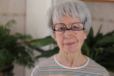 Senior woman wearing her eyeglasses upside down clipart