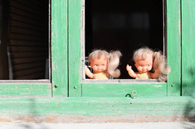 Pencereden bakan ürkütücü ikiz kardeş bebekleri.
