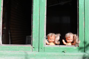 Pencereden bakan ürkütücü ikiz kardeş bebekleri.