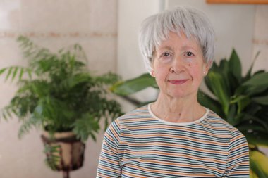 Kameraya gülümseyen yaşlı kadın.