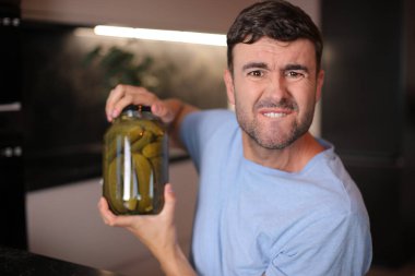 Arka planda turşuları seven bir adam, yakın plan.