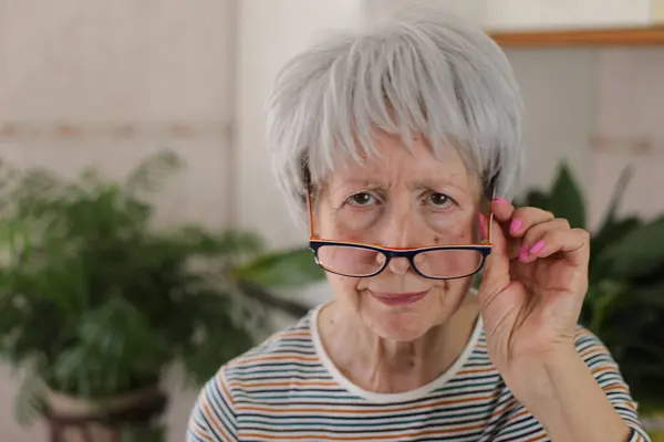 stock image Senior woman squinting and putting her eyeglasses down