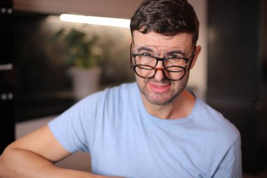 Aynı anda üç farklı gözlük takan adam.