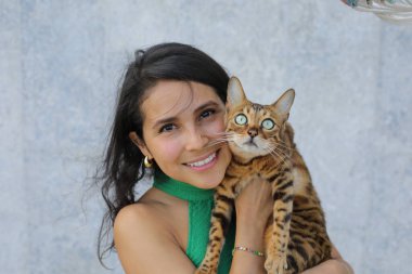 Bengal kedisi olan güzel bir kadın.