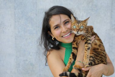Bengal kedisi olan güzel bir kadın.