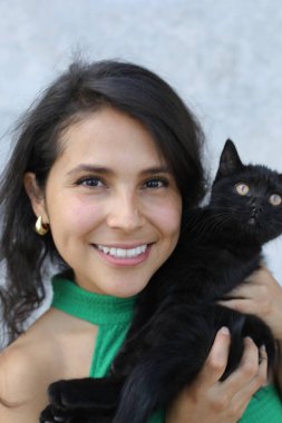 Çok tatlı siyah bir kedisi olan güzel bir kadın.