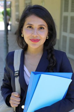 Dosyalarla poz veren güzel İspanyol öğrenci kadın.