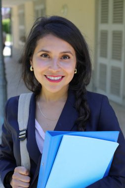 Dosyalarla poz veren güzel İspanyol öğrenci kadın.