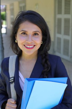 Dosyalarla poz veren güzel İspanyol öğrenci kadın.