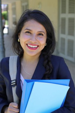Dosyalarla poz veren güzel İspanyol öğrenci kadın.