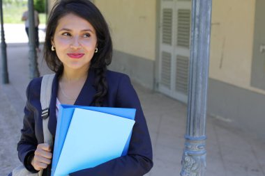 Dosyalarla poz veren güzel İspanyol öğrenci kadın.