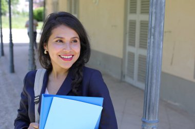 Dosyalarla poz veren güzel İspanyol öğrenci kadın.