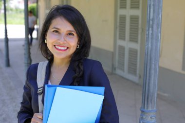 Dosyalarla poz veren güzel İspanyol öğrenci kadın.