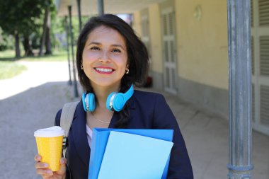 Kahve ve dosyalarla poz veren güzel İspanyol öğrenci kadın.