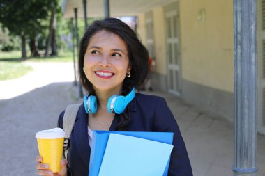 Kahve ve dosyalarla poz veren güzel İspanyol öğrenci kadın.