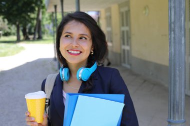 Kahve ve dosyalarla poz veren güzel İspanyol öğrenci kadın.