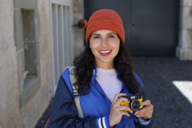 Güzel bir bayan turist klasik bir kamerayla fotoğraf çekiyor.