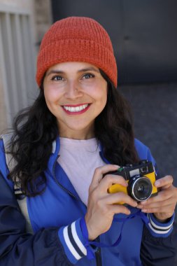 Güzel bir bayan turist klasik bir kamerayla fotoğraf çekiyor.