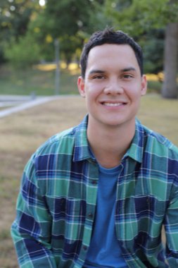 Park yerinde mavi gömlekli genç yakışıklı bir adam.