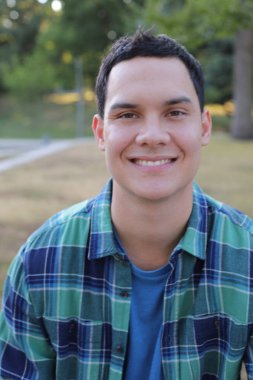 Park yerinde mavi gömlekli genç yakışıklı bir adam.