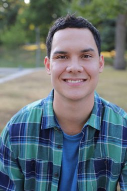 Park yerinde mavi gömlekli genç yakışıklı bir adam.