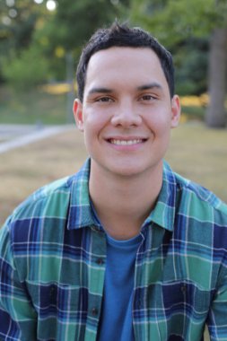 Park yerinde mavi gömlekli genç yakışıklı bir adam.