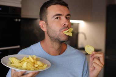 Dudaklarının arasında patates cipsi olan ördek gibi davranan adam.