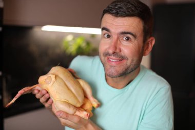 Tavuğu şefkatle tutan adamın komik görüntüsü.