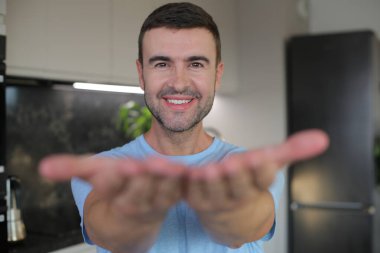 Yakışıklı adam parmaklarıyla bir işaret yapıyor.