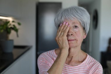 Kıdemli kadın sadece bir gözünü kapatarak görüşünü test ediyor.