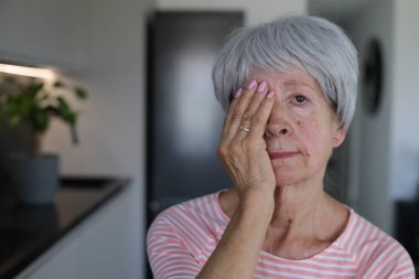 Kıdemli kadın sadece bir gözünü kapatarak görüşünü test ediyor.