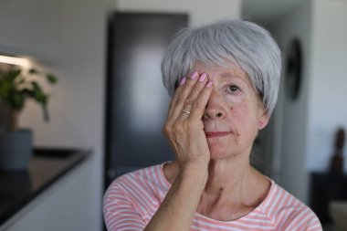 Kıdemli kadın sadece bir gözünü kapatarak görüşünü test ediyor.