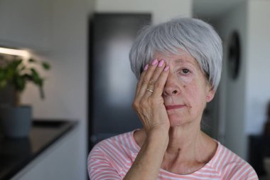 Kıdemli kadın sadece bir gözünü kapatarak görüşünü test ediyor.