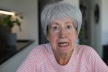 Kıdemli kadın alt dişlerini gösteriyor.