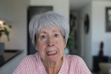 Senior woman showing her lower teeth clipart