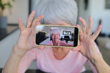 Yaşlı kadın evde selfie çekiyor.