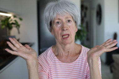 Onaylamayan bir ifadeyle çok eleştirel görünüşlü yaşlı bir kadın.