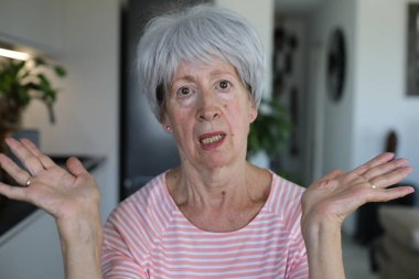 Onaylamayan bir ifadeyle çok eleştirel görünüşlü yaşlı bir kadın.