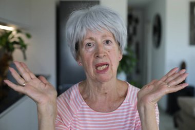 Onaylamayan bir ifadeyle çok eleştirel görünüşlü yaşlı bir kadın.