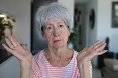 Onaylamayan bir ifadeyle çok eleştirel görünüşlü yaşlı bir kadın.