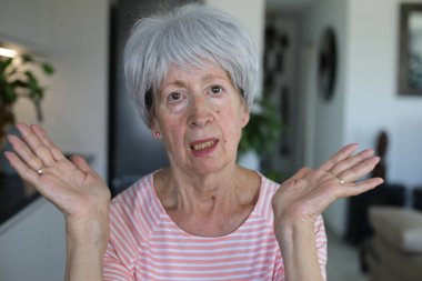 Onaylamayan bir ifadeyle çok eleştirel görünüşlü yaşlı bir kadın.