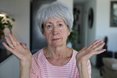 Onaylamayan bir ifadeyle çok eleştirel görünüşlü yaşlı bir kadın.