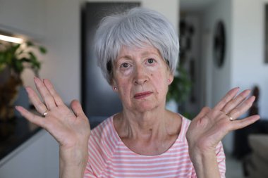 Onaylamayan bir ifadeyle çok eleştirel görünüşlü yaşlı bir kadın.