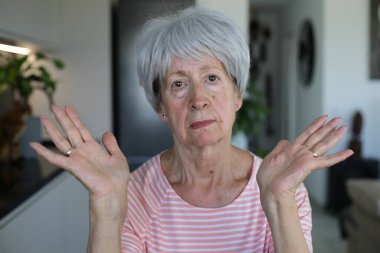 Onaylamayan bir ifadeyle çok eleştirel görünüşlü yaşlı bir kadın.