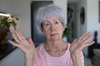 Onaylamayan bir ifadeyle çok eleştirel görünüşlü yaşlı bir kadın.