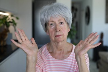 Onaylamayan bir ifadeyle çok eleştirel görünüşlü yaşlı bir kadın.