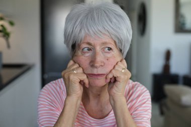 Mutsuz yaşlı kadın oturma odasında