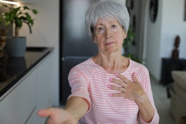 Senior woman begging for something with hand gesture clipart